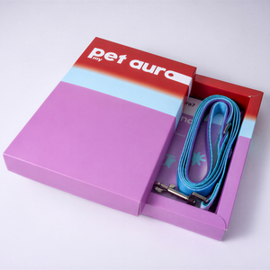 A purple and red 'pet aura' branded gift box shown open on a white background, revealing a bright blue lead inside.