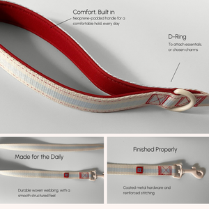 A close-up and detail view of a woven strap product with text callouts explaining features: Comfort, Built-in neoprene padded handle; D-Ring for attachments; Made for the Daily durable woven webbing; Finished Properly coated metal hardware and reinforced stitching.